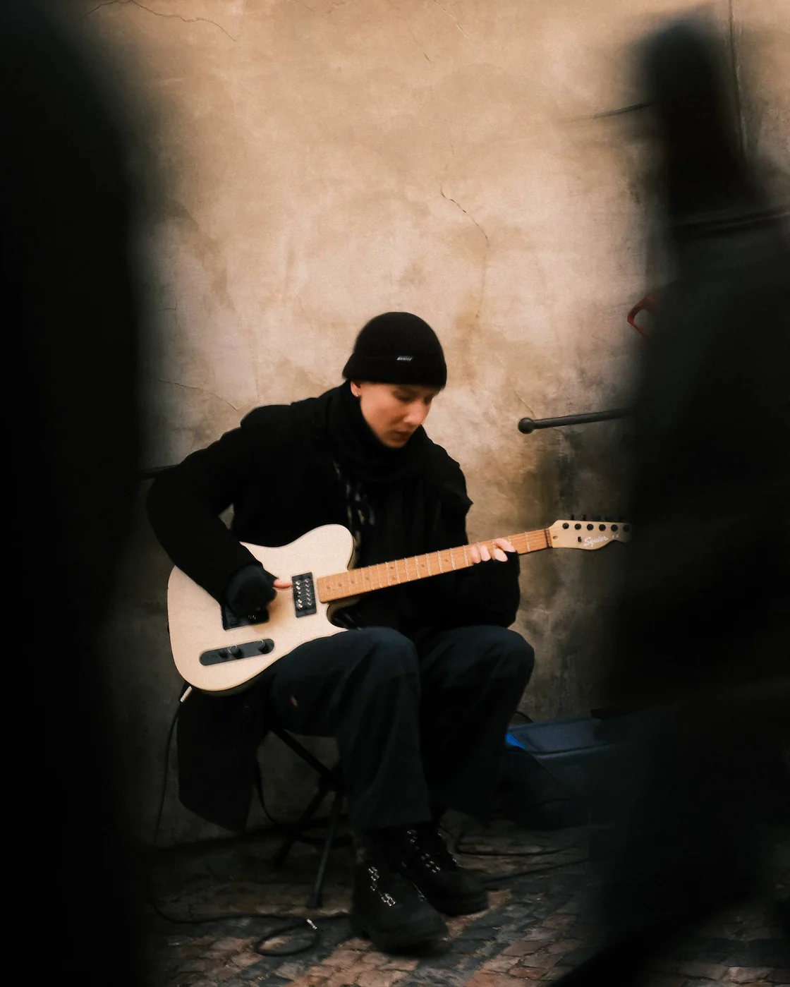 Guitarist playing a white electric guitar
